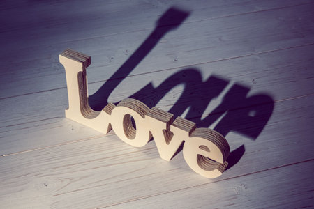 Digitally generated image of word love on wooden flooringの写真素材