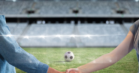 Composition of businessman and businesswoman shaking hands over sports stadium. sport and competition, business and finance concept digitally generated image.の写真素材