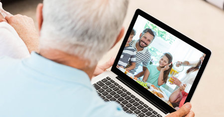 Senior Caucasian couple using a laptop with Caucasian family, having a video meeting and interacting...