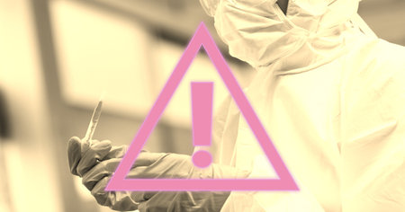 Digital illustration of a pink warning sign over a scientist wearing a face mask, protective suit and gloves, using a pipette in the background. x Medicine public health pandemic coronavirus Covid 19 outbreak concept digital composite.の写真素材