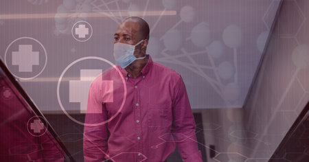 Digital illustration of a man wearing a face mask, walking up the stairs over medical icons, DNA strain in the background. Medicine public health pandemic coronavirus Covid 19 outbreak concept digital composite.の写真素材