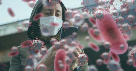 Digital illustration ofmacro Covid-19 cells floating over a woman wearing a face mask, using a...