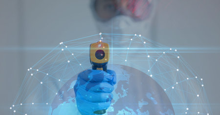 Digital illustration of a globe with a web of connections over a doctor wearing protective clothes, using an electronic thermometer. Coronavirus Covid-19 pandemic concept digitally generatedの写真素材
