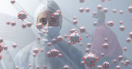 Digital illustration of macro Covid-19 cells floating with a Caucasian woman wearing protective clothes over a mixed race man wearing face mask. Coronavirus Covid-19 pandemic concept digital compositeの写真素材