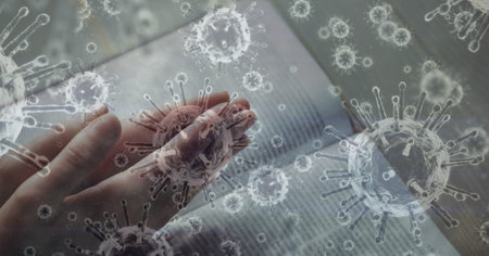 Digital illustration of macro Covid-19 cells floating over Caucasian hands praying and the Bible, praying. Religious faith in time of coronavirus global pandemic concept, digital composite.の写真素材