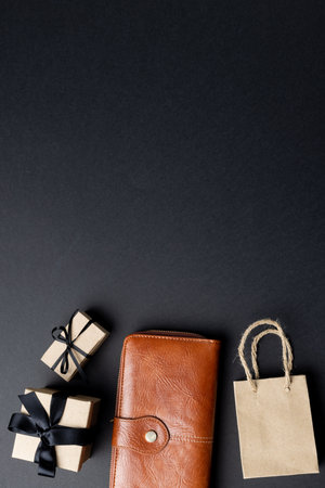 Composition of bag, wallet and presents with copy space on gray background. Retail, shopping and black friday concept.の写真素材