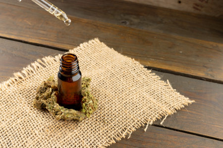 Image of cbd oil in bottle on wooden background. Cbd oil, medical marihuana, cannabis medicament concept.の写真素材