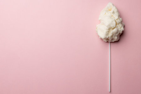 Horizontal image of homemade white candy floss on stick, on pink background with copy space. Tasty home made sweet foods.の写真素材