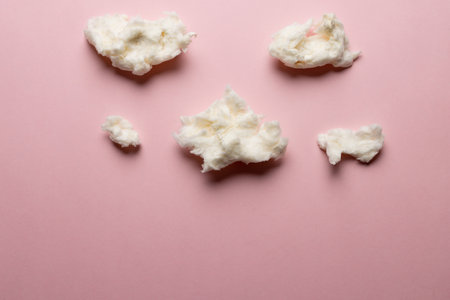 Horizontal image of tufts of homemade white candy floss, on pink background with copy space. Tasty...