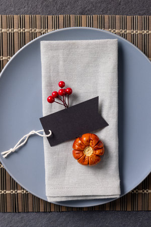 Overhead view of thanksgiving place setting with tag and autumn decoration on slate. Thanksgiving, autumn, fall, american tradition and celebration concept.の写真素材