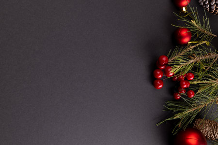 Image of christmas decorations with baubles and copy space on black background. Christmas, tradition...