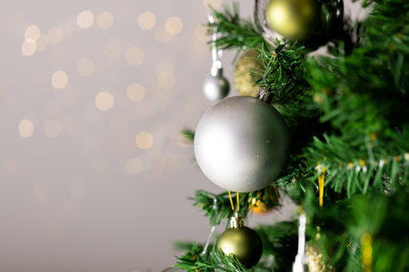 Image of christmas tree with baubles decoration and copy space on grey background. Christmas,...