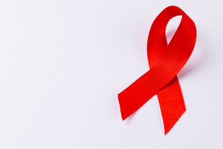 Image of red ribbon lying on white surface. Health, medicine, prevention and heart illnesses awareness concept.の写真素材