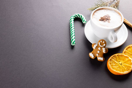 Image of cup of cappuccino coffee and christmas gingerbread man with copy space on grey. Christmas, tradition and celebration concept.の写真素材