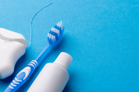 Image of toothbrush, toothpaste and dental string on blue surface. Health, dentistry, dental accessories and taking care of teeth concept.の写真素材
