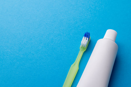 Image of toothbrush and toothpaste on blue surface. Health, dentistry, dental accessories and taking...