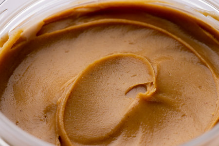 Image of close up of jar with peanut butter on white surface. Food, breakfast, nutrition and american cuisine concept.の写真素材