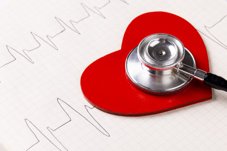 Image of red heart and stethoscope on white surface with heart rate. Health, medicine, prevention and heart illnesses awareness concept.の写真素材