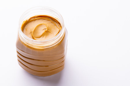 Image of jar with peanut butter on white surface. Food, breakfast, nutrition and american cuisine concept.の写真素材