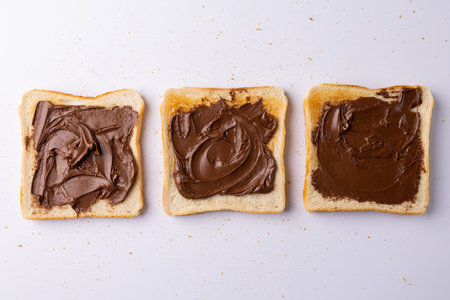 Image of bread slices with cream chocolate on white background. Food, breakfast, nutrition and...