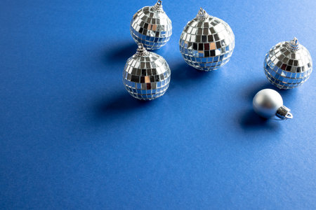 Composition of close up of new years baubles on blue background. New year's eve party,...