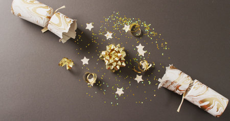 Image of christmas crackers, stars and decoration on grey background. Christmas, tradition and...