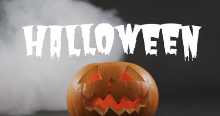 Image of halloween text over carved pumpkin on black background. Halloween, autumn, fall, festivity tradition and celebration concept digitally generated image.の写真素材