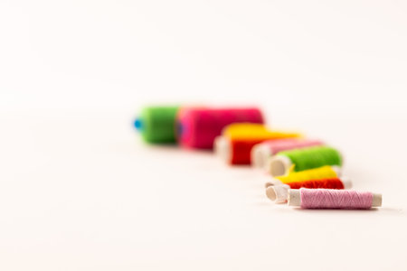 Composition of colourful sewing crewels on white background with copy space. National craft month,...