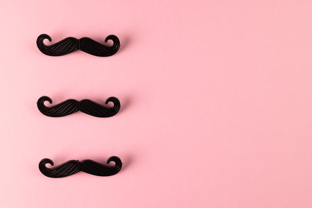 Composition of fake moustaches on pink background with copy space. Fake moustache day, party, celebration and costume concept.の写真素材