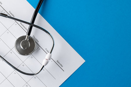 Composition of stethoscope with calendar on blue background with copy space. Medical services, healthcare and health awareness concept.の写真素材