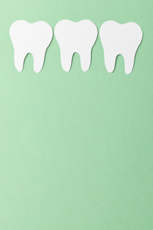 Vertical composition of white teeth on green background with copy space. Medical services, healthcare and dental health awareness concept.の写真素材