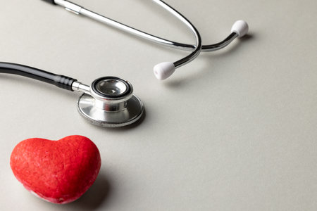Composition of stethoscope and red heart on grey background with copy space. Medical services, healthcare and health awareness concept.の写真素材