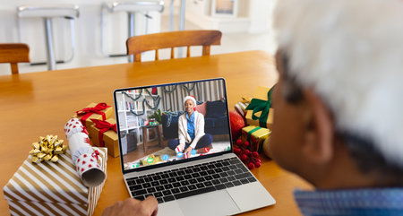 Senior biracial man having christmas video call with african american woman. Communication...