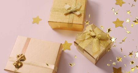 Multiple golden star icons floating against christmas gifts on white surface. christmas festivity and celebration conceptの写真素材