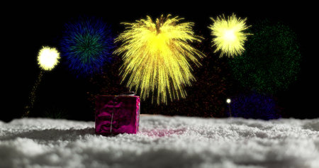 Image of christmas present in snow and yellow fireworks exploding in night sky. christmas, new year, celebration, party and tradition concept digitally generated image.の写真素材