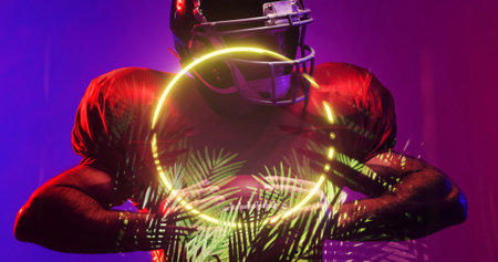 American football player wearing helmet and holding ball by illuminated circle and plants. Composite, sport, competition, illustration, glowing, nature, shape and abstract concept.の写真素材