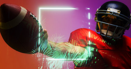 Close-up of american football player wearing helmet raising hand with ball by rectangle and plants. Copy space, composite, illuminated, sport, competition, illustration, nature, shape and abstract.の写真素材