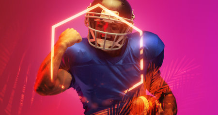 Cheerful american football player gesturing while standing by illuminated hexagon and plants. Purple, achievement, happy, composite, sport, competition, illustration, glowing, nature, shape, abstract.の写真素材