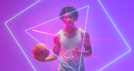 Composite of illuminated geometric shapes over biracial male player holding basketball, copy space. Purple, sport, competition, illustration, glowing, shape and abstract concept.の写真素材