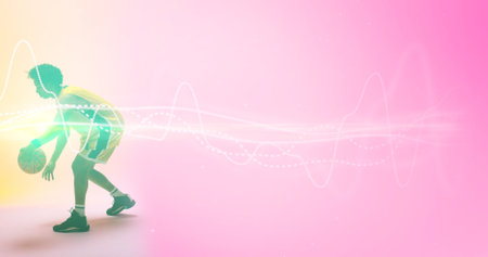 Composite of biracial basketball player dribbling ball by illuminated lines over pink background....