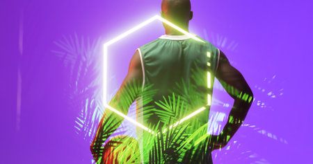 Rear view of african american basketball player standing over glowing hexagon and plants, copy...