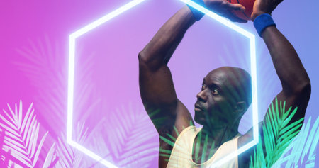 Bald african american basketball player with arms raised throwing ball by hexagon and plants. Composite, copy space, playing, sport, competition, illustration, illuminated, nature, shape, abstract.の写真素材
