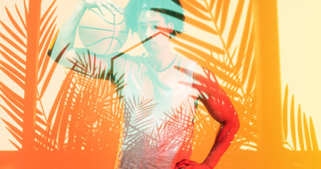 Composite of biracial basketball player holding ball on shoulder over hexagon and plants. Sport, competition, illustration, glowing, nature, shape and abstract concept.の写真素材