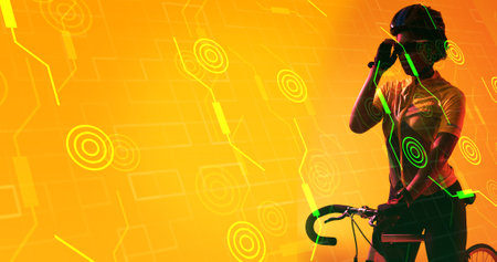 Biracial female athlete wearing glasses and helmet with bike over illuminated circles and lines. Yellow, composite, copy space, sport, cycling, racing, competition, shape and abstract concept.の写真素材