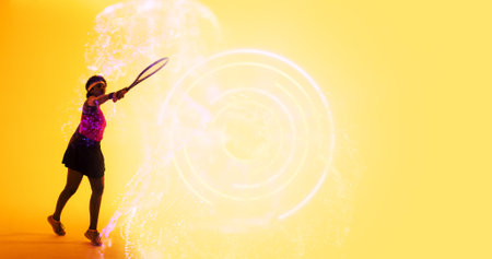 Biracial female tennis player with racket by circular and abstract pattern on yellow background....
