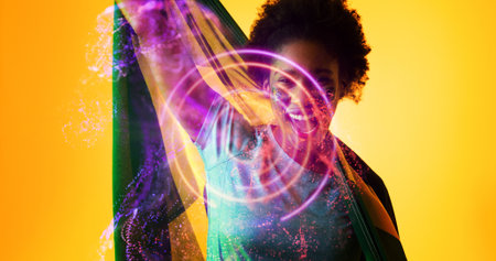 Cheerful biracial female soccer player with brazilian flag screaming over illuminated circles....