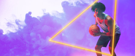 Composite of biracial male basketball player with ball standing by triangle on blue smoky background. Copy space, sport, competition, illustration, illuminated, shape and abstract concept.の写真素材