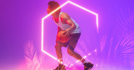 Biracial basketball player dribbling ball by illuminated hexagon and plants on violet background. Composite, playing, copy space, sport, competition, illustration, glowing, nature, shape and abstract.の写真素材