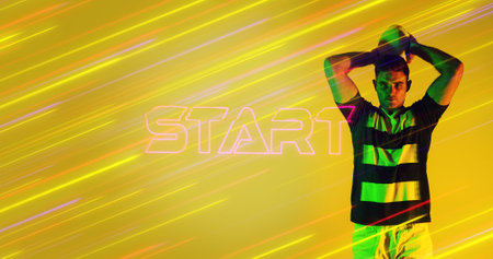 Caucasian rugby player throwing ball by illuminated start text over colorful long exposure....