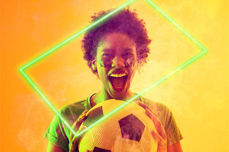 Rectangle neon over african american female fan with ball celebrating victory during soccer match....
